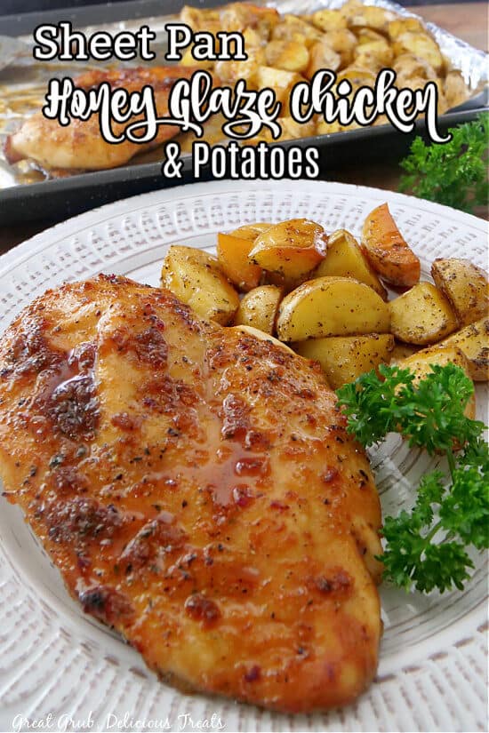 Sheet pan chicken and potatoes on a white plate with parsley in the background.