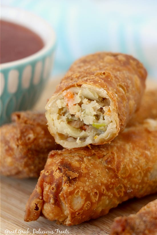 A close up of golden crispy egg rolls with a bite taken out of one of them that were frozen and cooked in an air fryer.