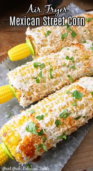 Three pieces of air fryer Mexican street corn sitting on a silver tray.