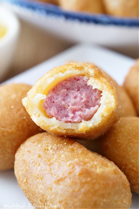 mini corn dogs stacked up with a bite taken out of it.