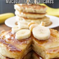 Two plates with stack of pancakes on white plates, topped with maple syrup.