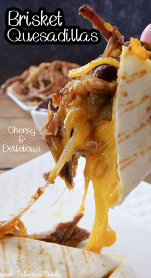 A quesadilla with stringy cheddar cheese, and brisket sticking out.