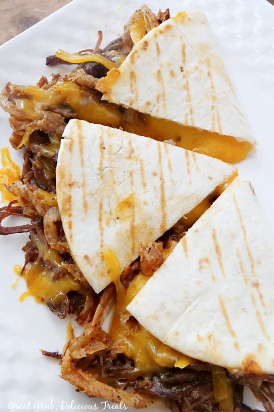 A quesadilla cut into three equal parts, with cheese and brisket sticking out.