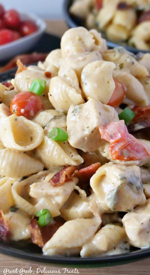 A close up of pasta, chicken pieces, tomatoes in a creamy sauce.