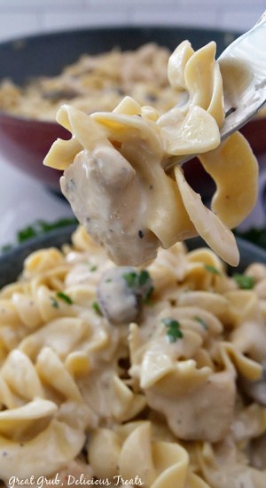 A close up of a bite of chicken stroganoff on a fork.