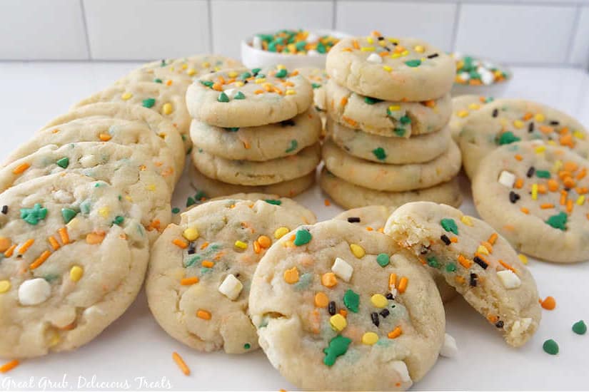 A couple dozen sugar cookies on a white surface.