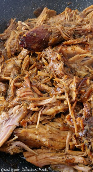 A dutch oven with shredded pulled pork in it.