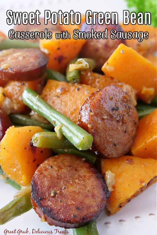 A close up of sweet potatoes, green beans and smoked sausage.