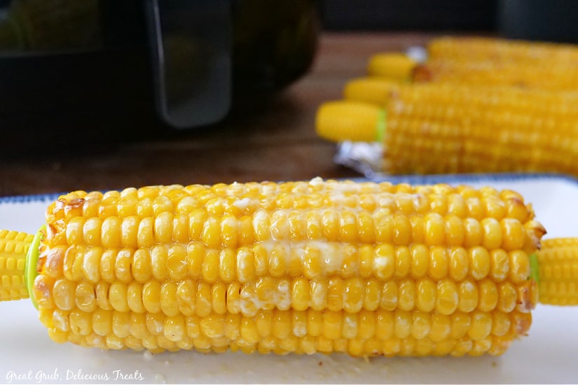 An air fried ear of corn on a white plate.