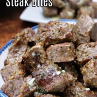 A white bowl with blue trim that is filled with seasoned steak bites.