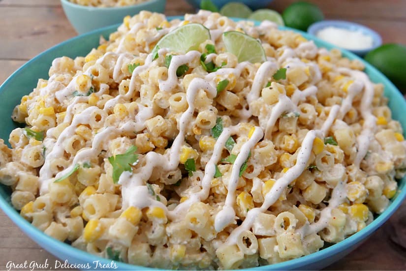 A landscape photo of a bowl of pasta salad loaded with pasta, corn, cilantro, and a street corn dressing.