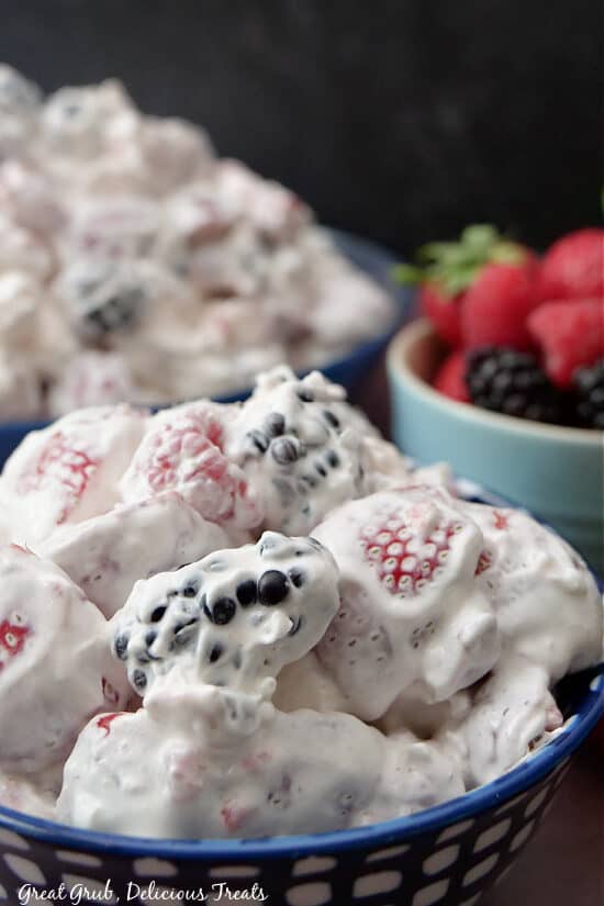A close up of a blue and white blow filled with a serving of berry fruit salad.