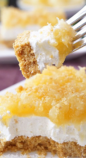 A close up of a bite of pineapple dessert on a fork.