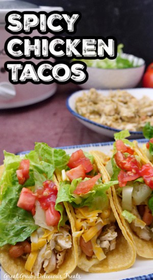 Three tacos lined up on a white plate, topped with fresh ingredients.