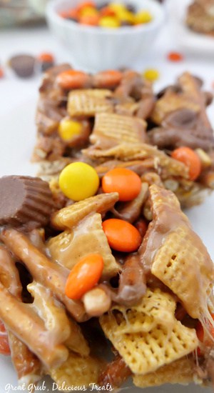 A white surface with two Chex mix bars with Reese's chocolate.
