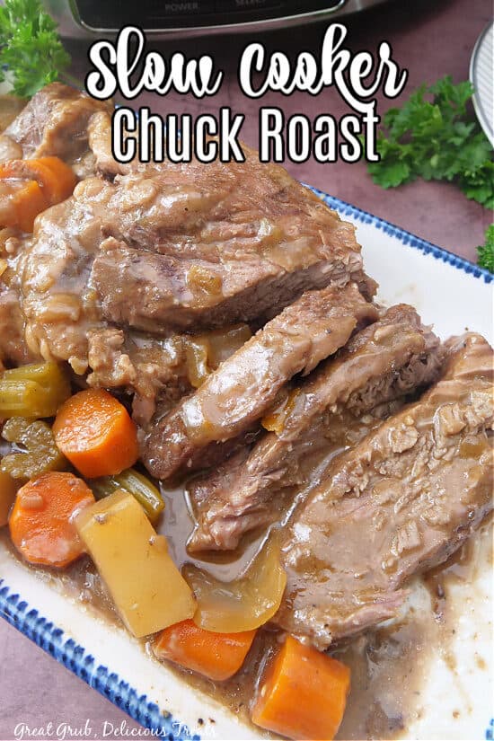 A white plate with blue trim with a slow cooked chuck roast and vegetables on it.