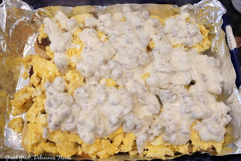 A baking dish filled with sliders, showing the layer of eggs and gravy sitting on top of sausage patties.