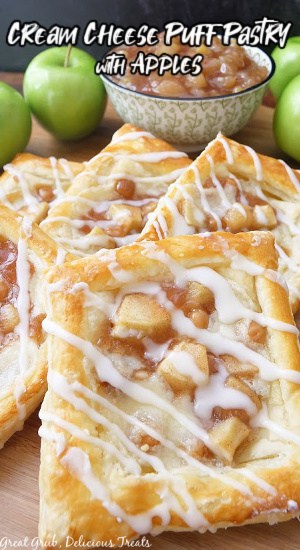 Apple pastries laid out on a wooden board with green apples and apple pie filling in the background.