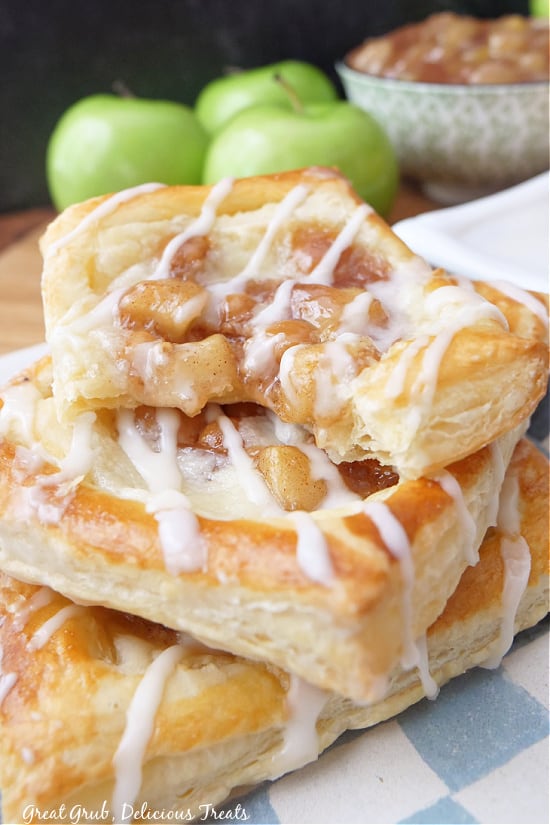 Three cream cheese apple pastries stacked up on top of one another.