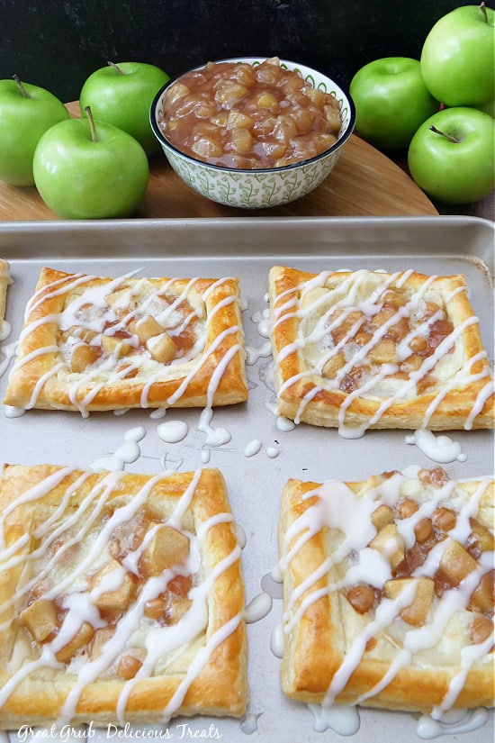 A large baking sheet with pastries on them, all drizzled with a homemade glaze.