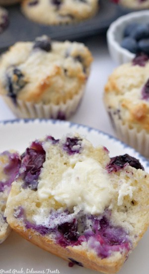 A muffin on a white plate with blue trim.