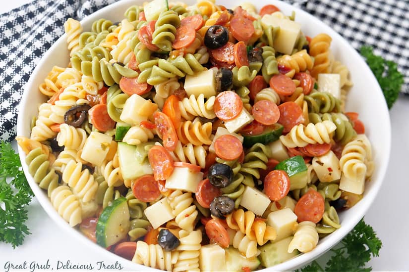 A white serving bowl with rotini pasta salad in it.