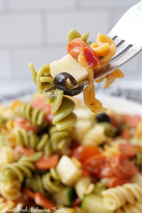 A bite of pasta salad on a fork .