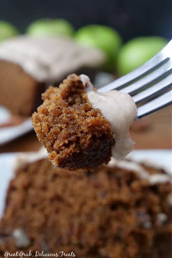 A close up of a bite of apple loaf cake on a fork.