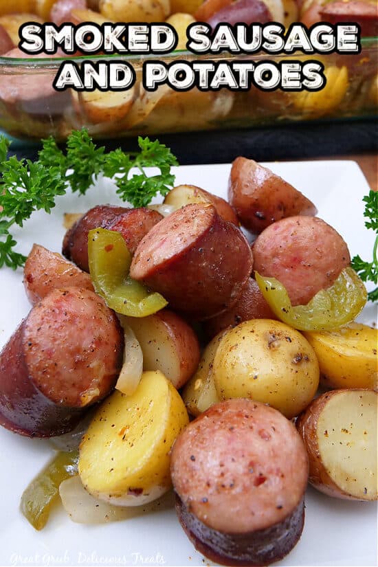 A white square plate with smoked sausage and potatoes on it.