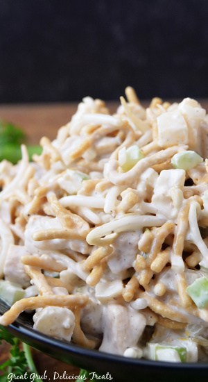 A close up view of a black bowl filled with a serving of Chinese Chicken Salad.
