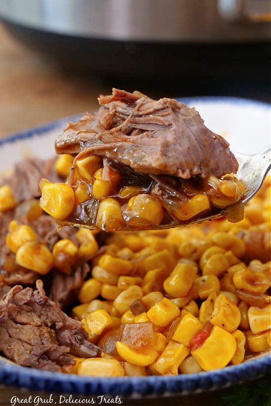 A big bite of chuck roast and corn on a spoon.
