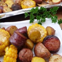 A title pic of smoked sausage, potatoes, and corn on a white plate.