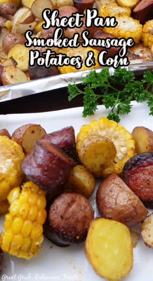 A white plate with a serving of sausage, corn, and potatoes on it.
