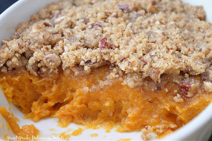 A horizontal photo of a white baking dish with sweet potato casserole in it.
