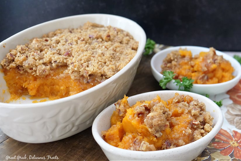 Three white bowls with sweet potato casserole in them.