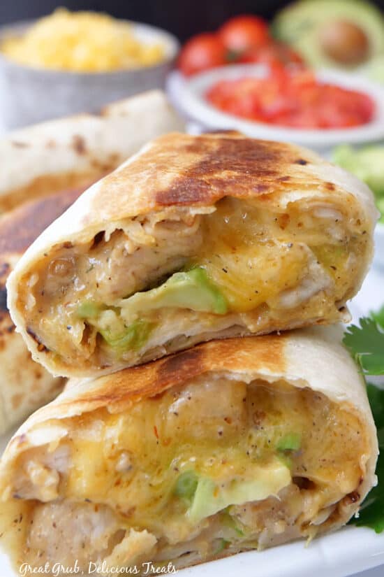 Two chicken burritos showing the inside ingredients.