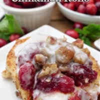 A cranberry cinnamon roll on a white plate.