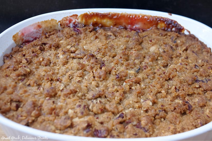 A casserole dish full of cranberry cobbler covered in a cobbler topping.