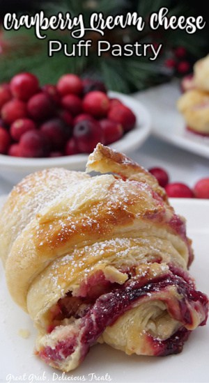 One puff pastry on a white plate filled with a cream cheese and cranberry filling.