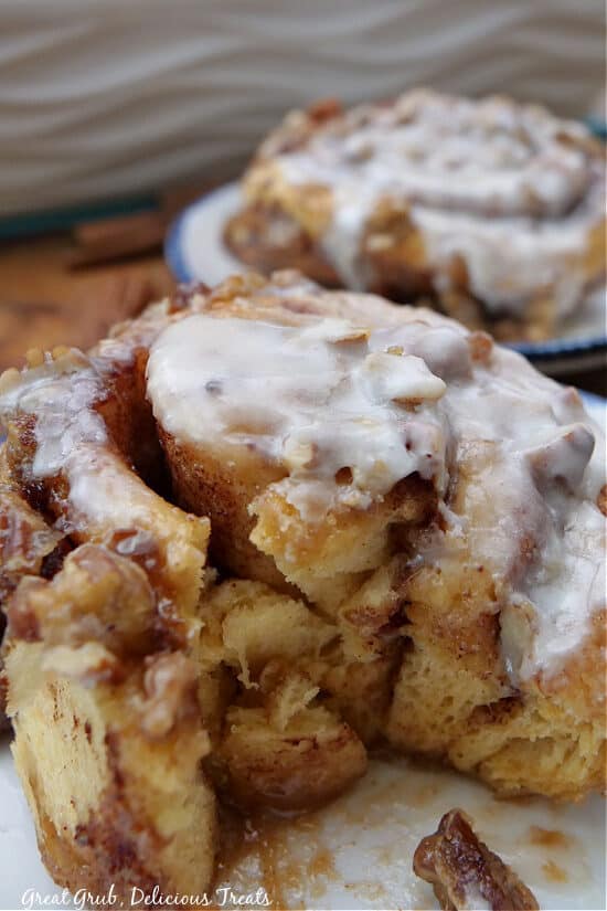 A close up of a cinnamon rolls with a bite taken out of it.