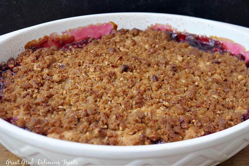 An oval baking dish with blackberry cobbler in it after being baked in the oven.