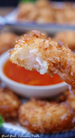 A close up of a coconut shrimp with a bite taken out of it.
