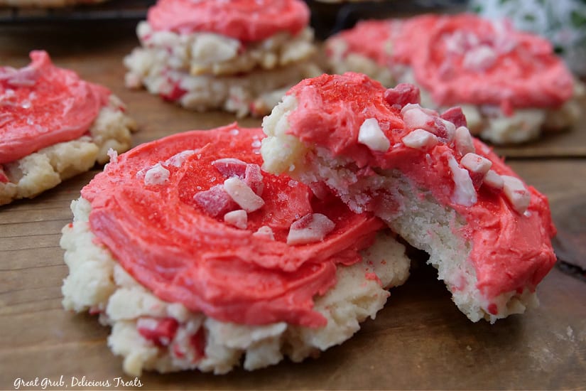 A horizontal photo of peppermint sugar cookies with a bite taken out of one of them.