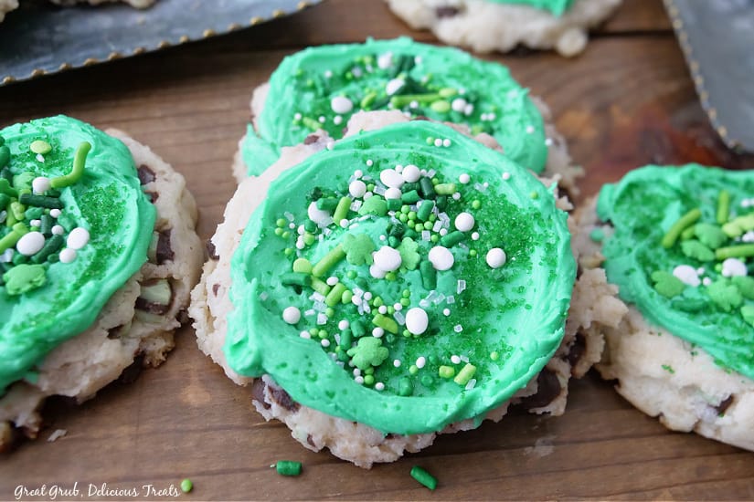 A close up of four St Patricks Day cookies with green frosting and candy sprinkles.