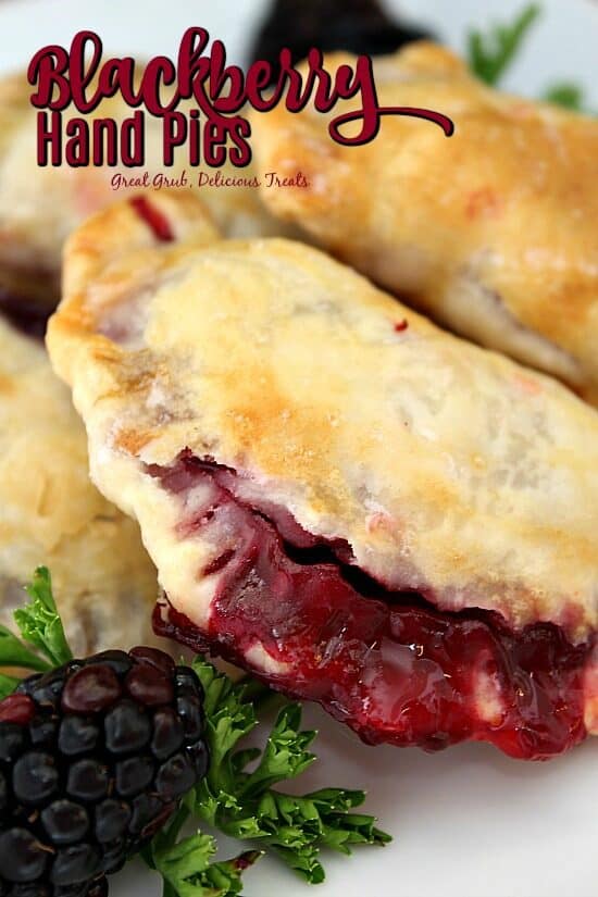 A close up photo of blackberry hand pies on a white plate with the title of the recipe at the top of the photo.