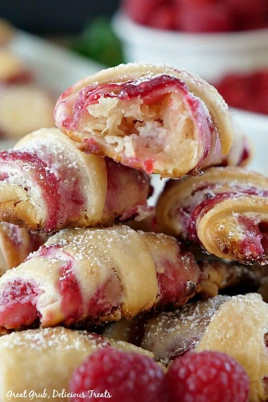 A stack of raspberry pastries with a bite taken out of one of them. 