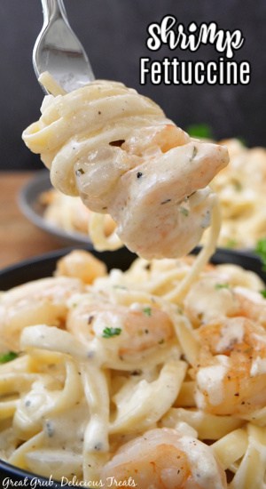 A fork with a bite of shrimp fettuccine on it.