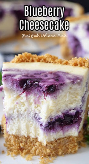 A piece of cheesecake with blueberry filling swirled in and on top of the cheesecake with a few bites out of it.