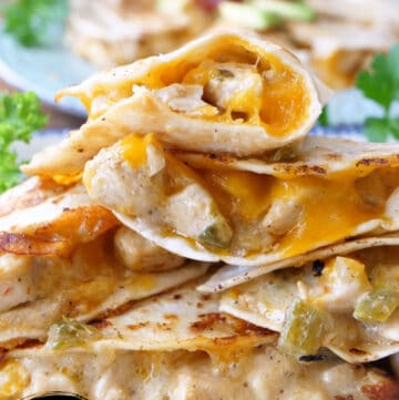 Chicken quesadillas stacked up on a white plate.