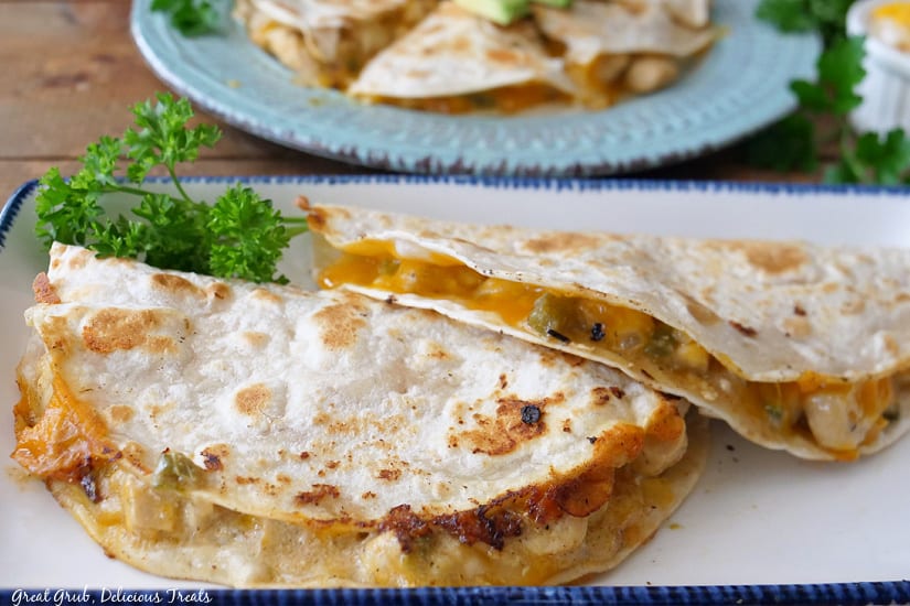 Two halves of quesadillas on a long white plate. 